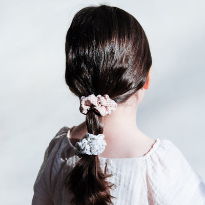 Brunette little girl wearing pretty gingham and floral scrunchies in a low ponytail hairstyle