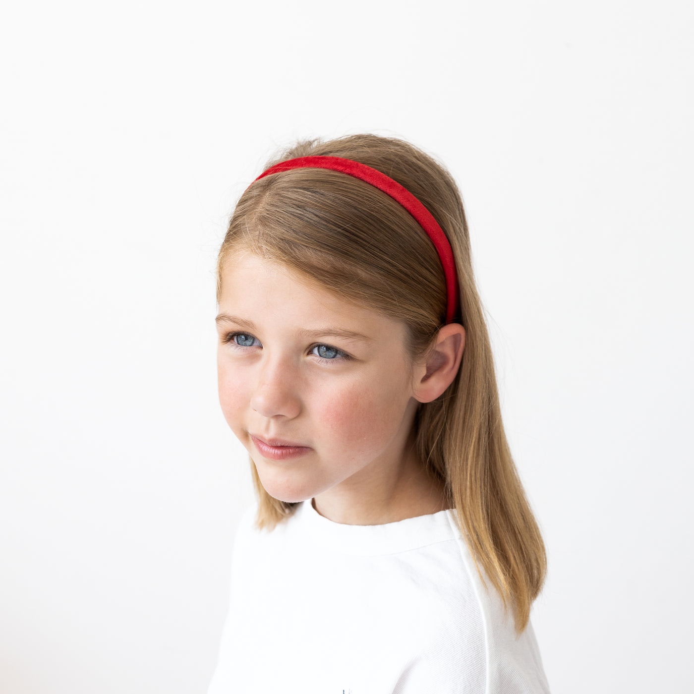 Little girl modelling a bright red velvet plain Alice band