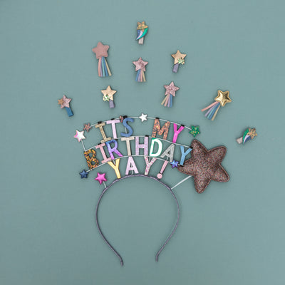 Birthday headband and sparkly star hair clips on green / blue background