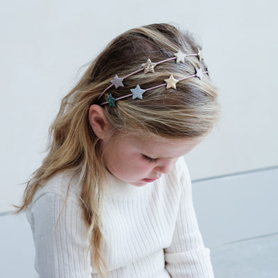 Little girl wearing a pretty glitter star double Alice band