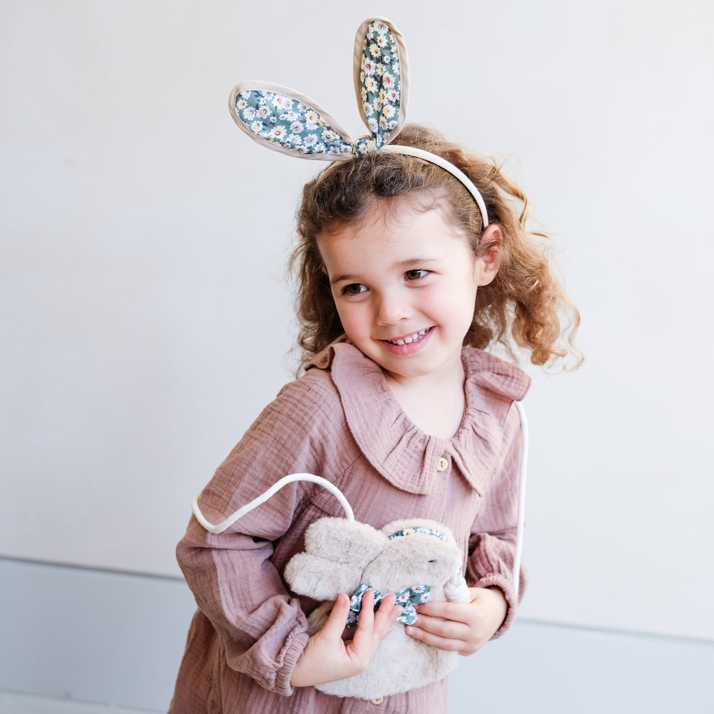 Floral print bunny rabbit ears on a little girl in a dress holding a  cute fluffy bunny bag