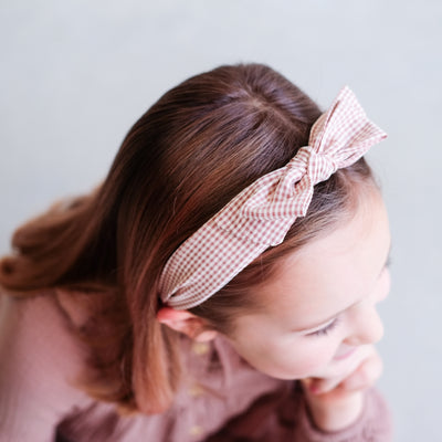 Dark blonde little girl with a dusky pink gingham fabric bow Alice band