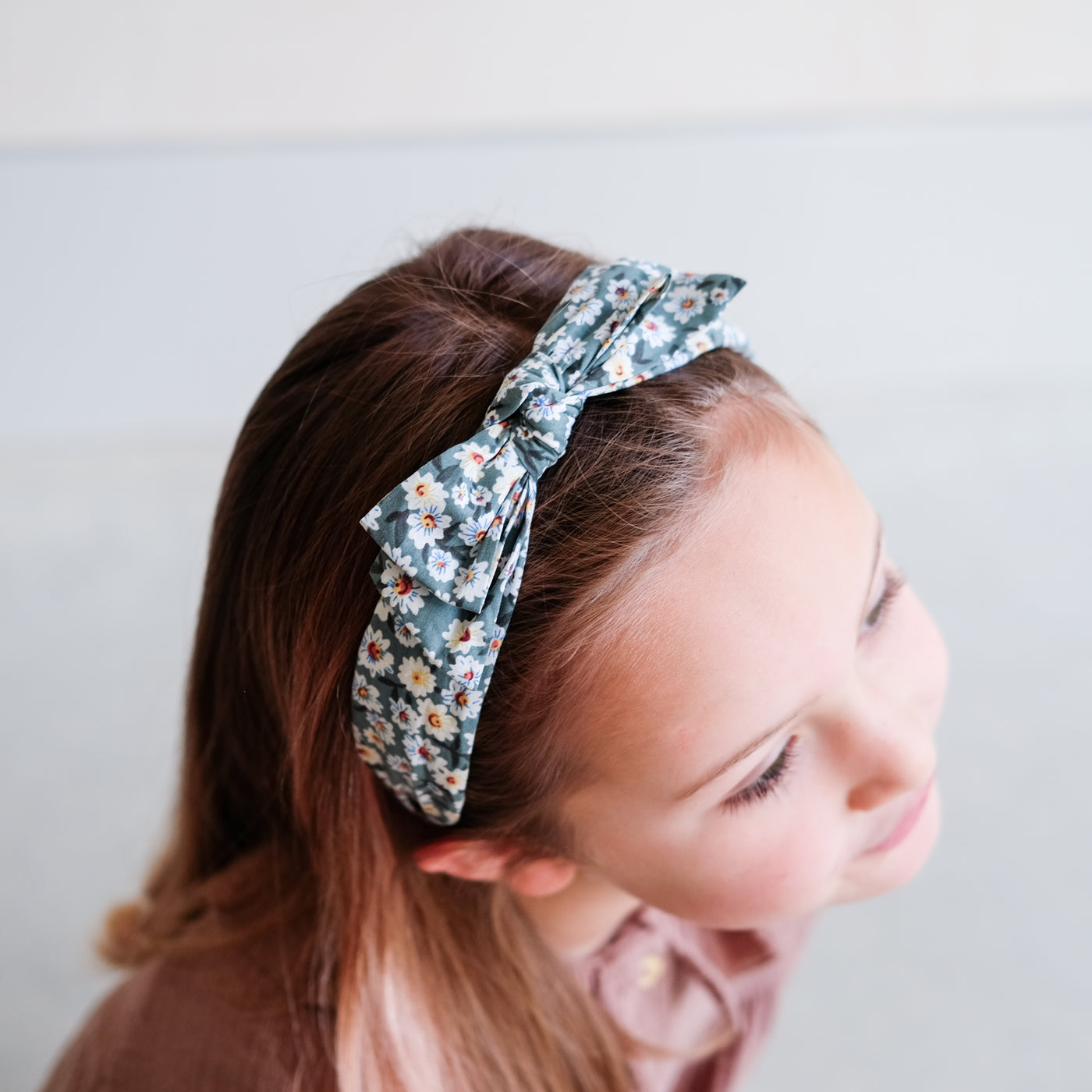Photo of daisy print headband with bow taken from above, worn by little girl