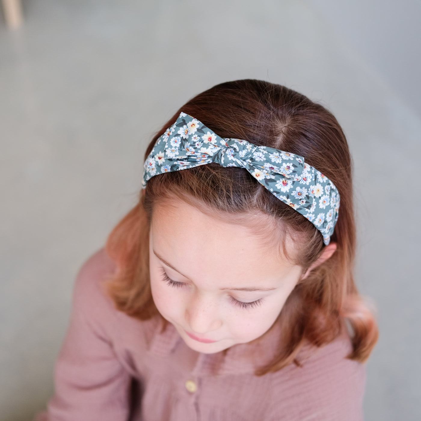 Sweet, floral print Alice band with bow worn by a little girl