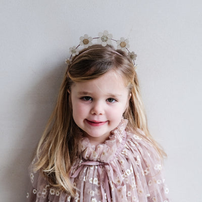 Little girl wearing pretty daisy headdress and a daisy print tulle cape