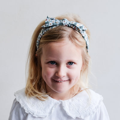 Smiling girl with floral print headband with bow
