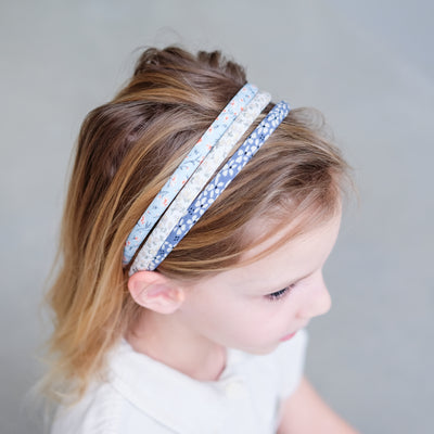 Little girl wearing three Alice bands in ditsy floral print fabrics