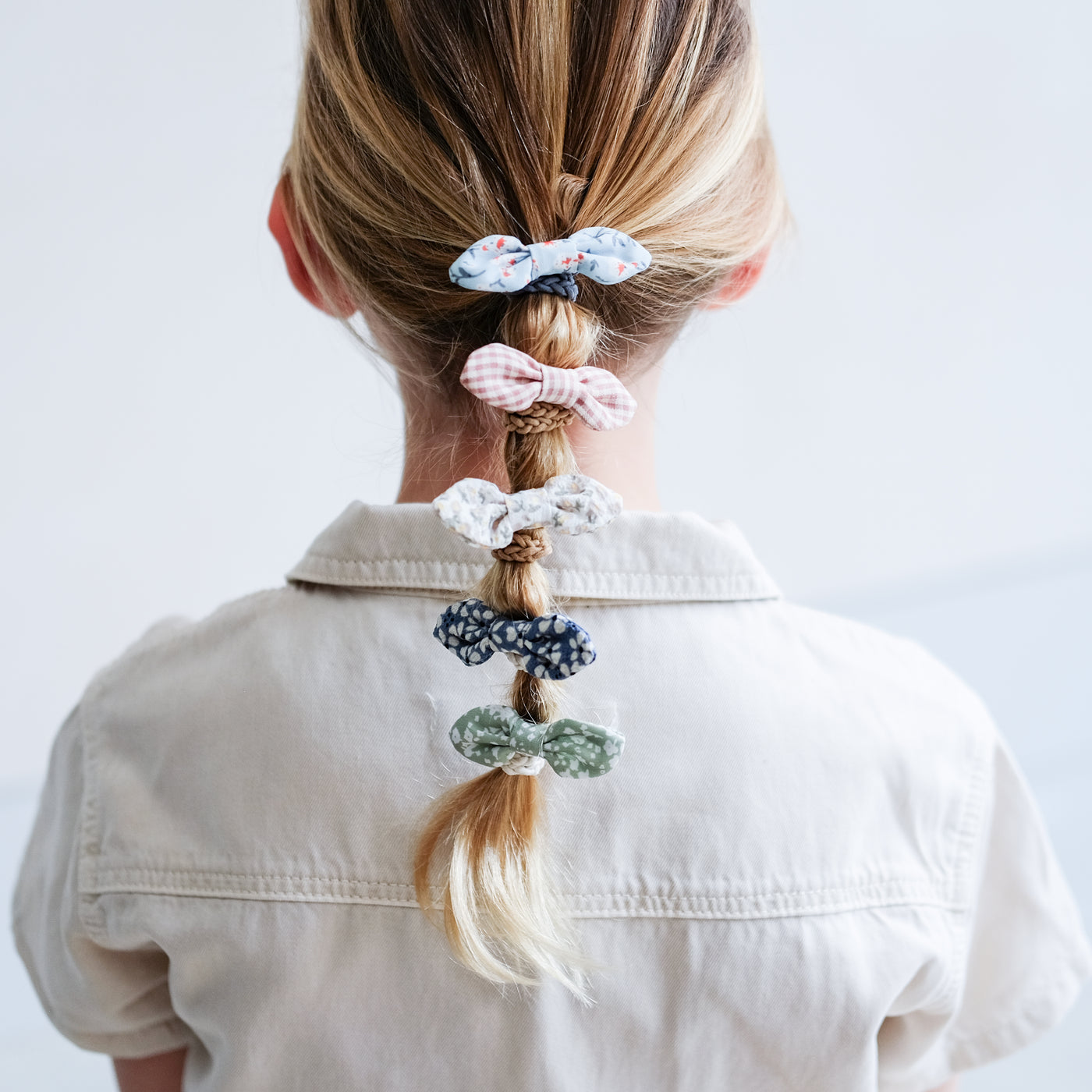 Little girl wearing cute floral fabric bow ponies in a bubble ponytail hairstyle 