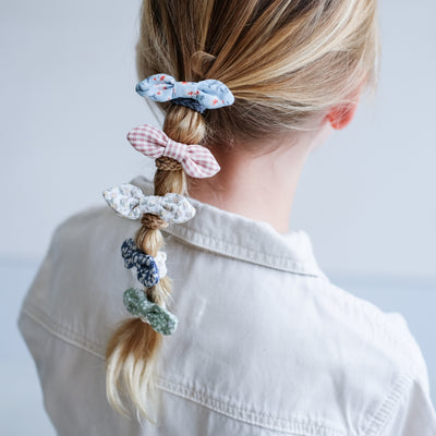 Pretty gingham and floral fabric bow ponies, featuring braided elastics, styled in a cute bubble ponytail
