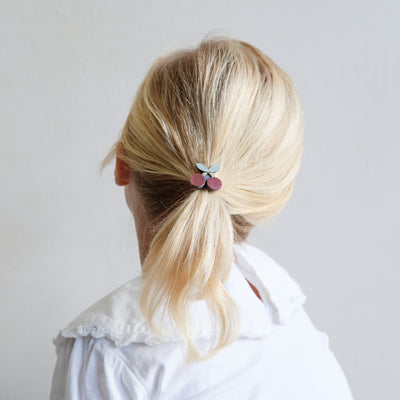 Ponytail tied at the back of head with a cute mini cherry pony, worn by little girl with fine hair