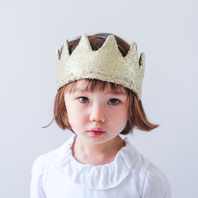 Little girl wearing gold sequin fabric crown