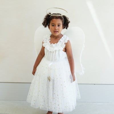 Dark haired little girl wearing a white tulle layered tutu, a gold halo headdress and a beautiful pair of angel wings