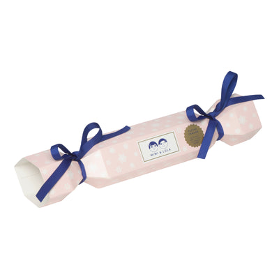 A luxury pre-filled cracker gift for children tied with navy grosgrain ribbons, containing jewellery and matching hair accessories