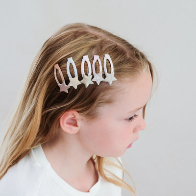 Five pack of mini star hair clips worn to the side of young dark blonde child - glitter and metallic fabrics