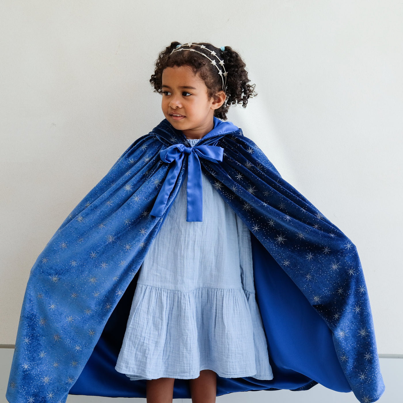 girl wearing an ice queen velvet cape against a white background