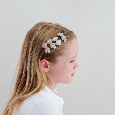 girl wearing tutu bow mini clips in her hair against a plain white background