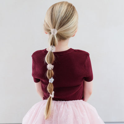 girl wearing Mini tulle rosette ponies in hair against white background