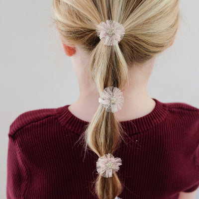 girl wearing Mini tulle rosette ponies in hair against white background