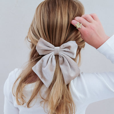 girl wearing velvet agnes oversized bow hair clip in her hair against a white background