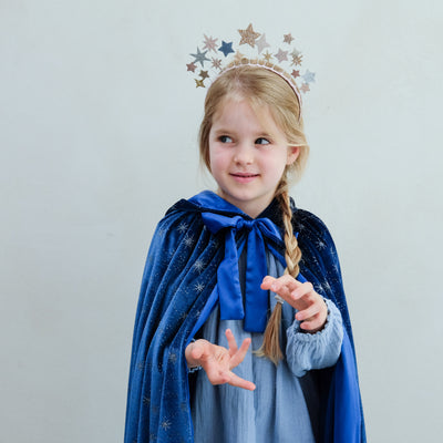 girl wearing an ice queen velvet cape against a white background