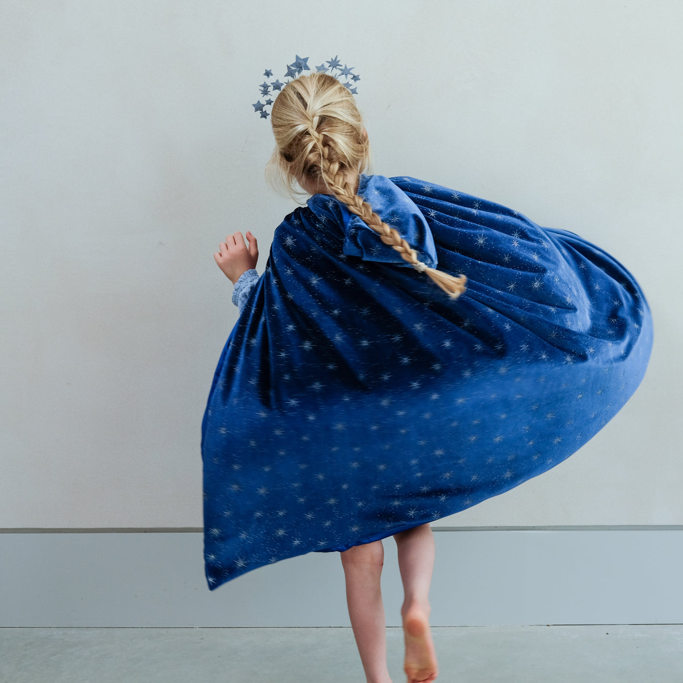 girl wearing an ice queen velvet cape against a white background