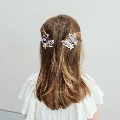 girl wearing shooting star trail hair clips in her hair against a white background