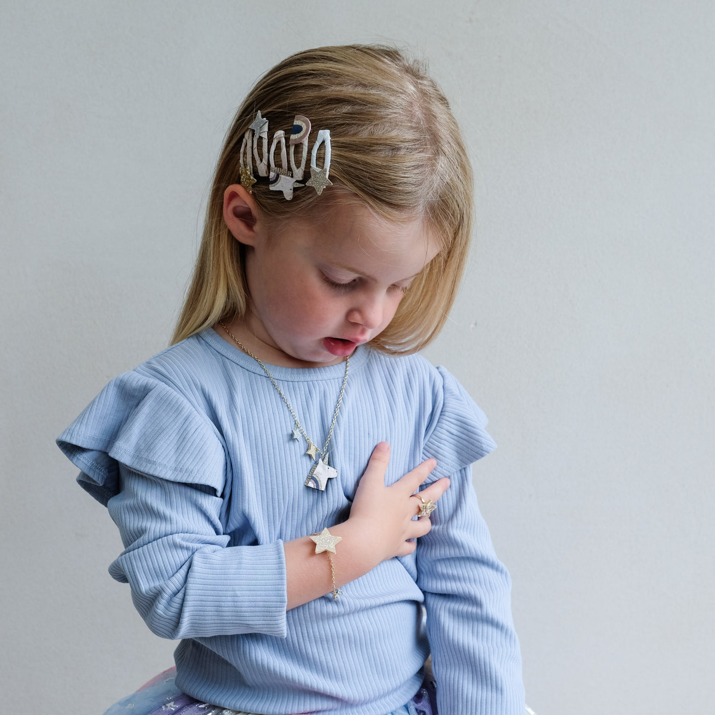 Young girl wearing a light blue sweater with a neutral background