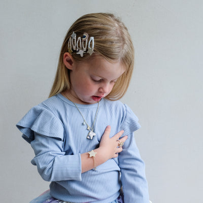 Young girl wearing a light blue sweater with a neutral background