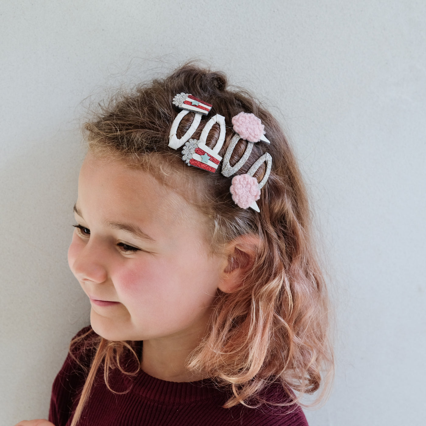 girl wearing popcorn and candy floss hair clips in her hair against a white background