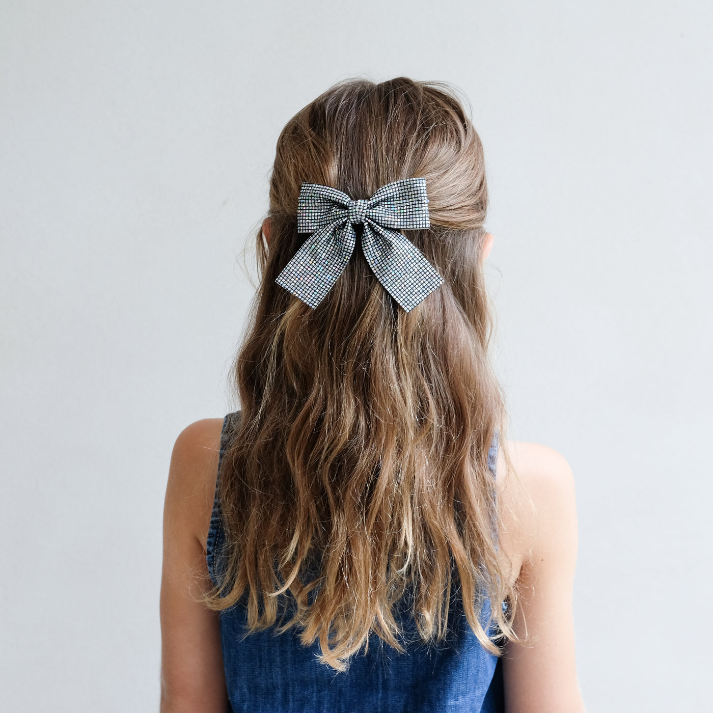 girl wearing Disco ball oversized bow in her hair against a white background