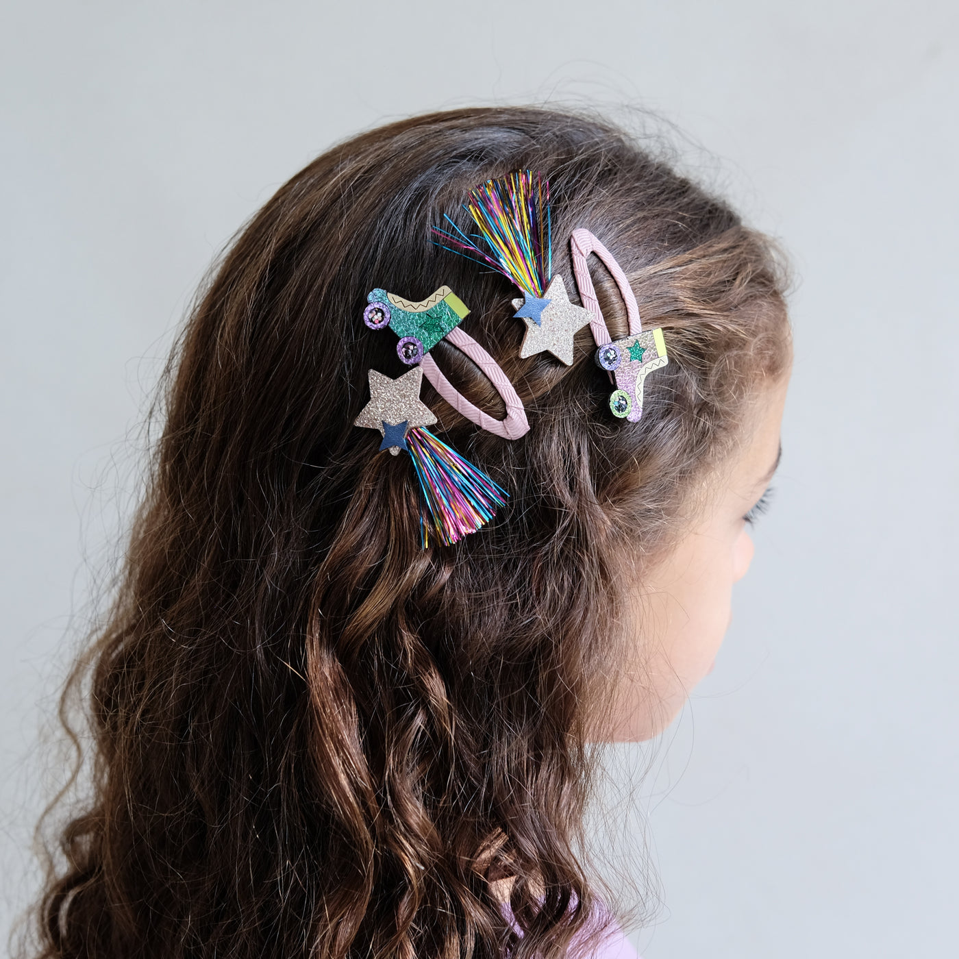 girl wearing roller skate hair clips in her hair against a white background