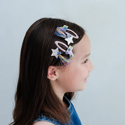girl wearing roller skate hair clips in her hair against a white background