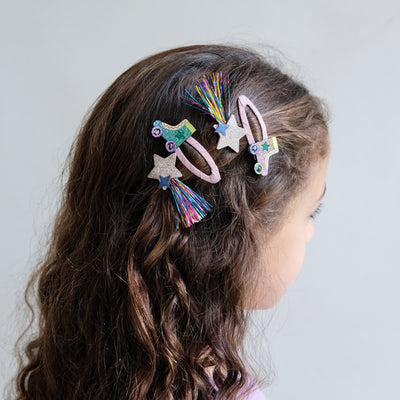 girl wearing roller skate hair clips in her hair against a white background