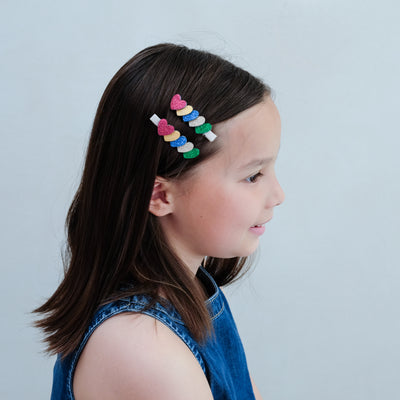 girl wearing jazzy layered heart clips in her hair against a white background