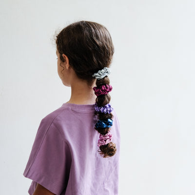 girl wearing dancing queen scrunchies in hair against a white background