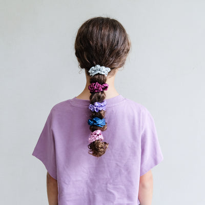 girl wearing dancing queen scrunchies in hair against a white background