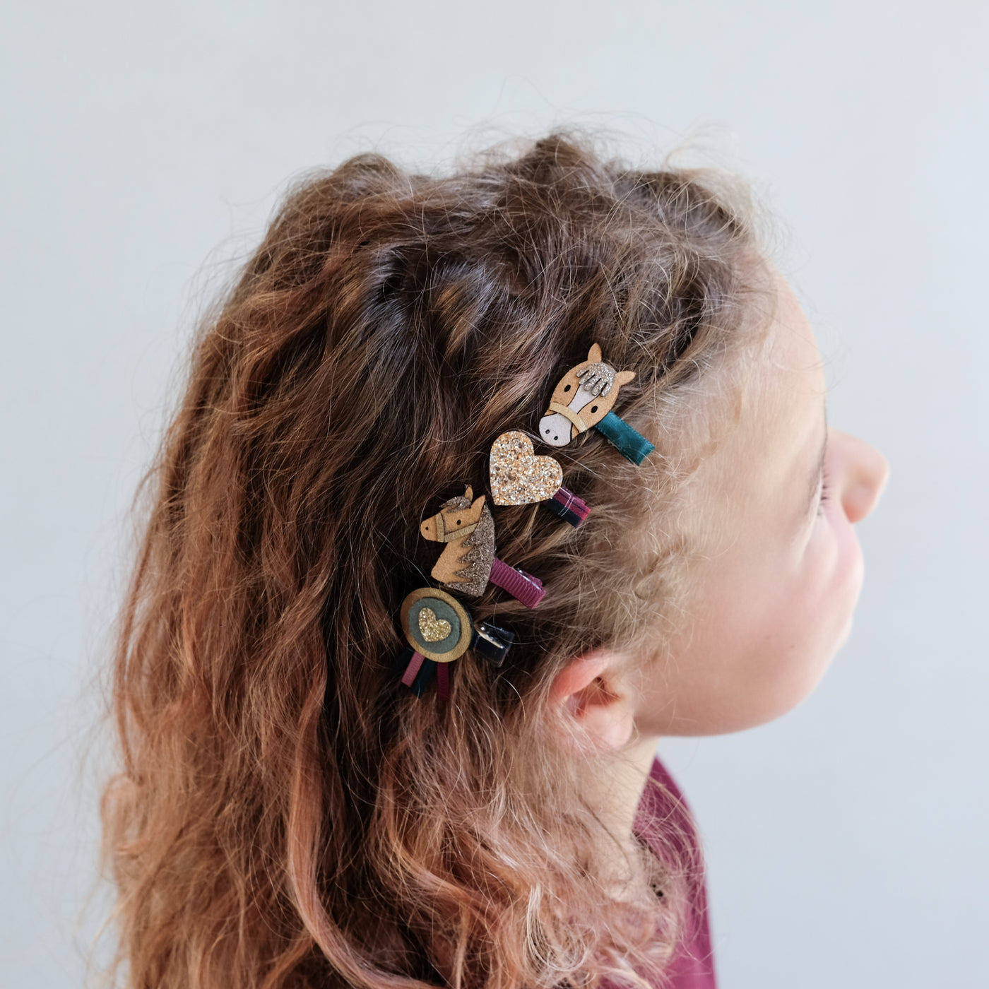 girl with curly hair wearing pony pals mini hair clips