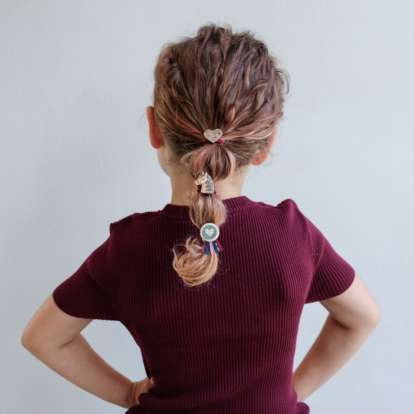 girl wearing pony pals ponies in hair against a white background