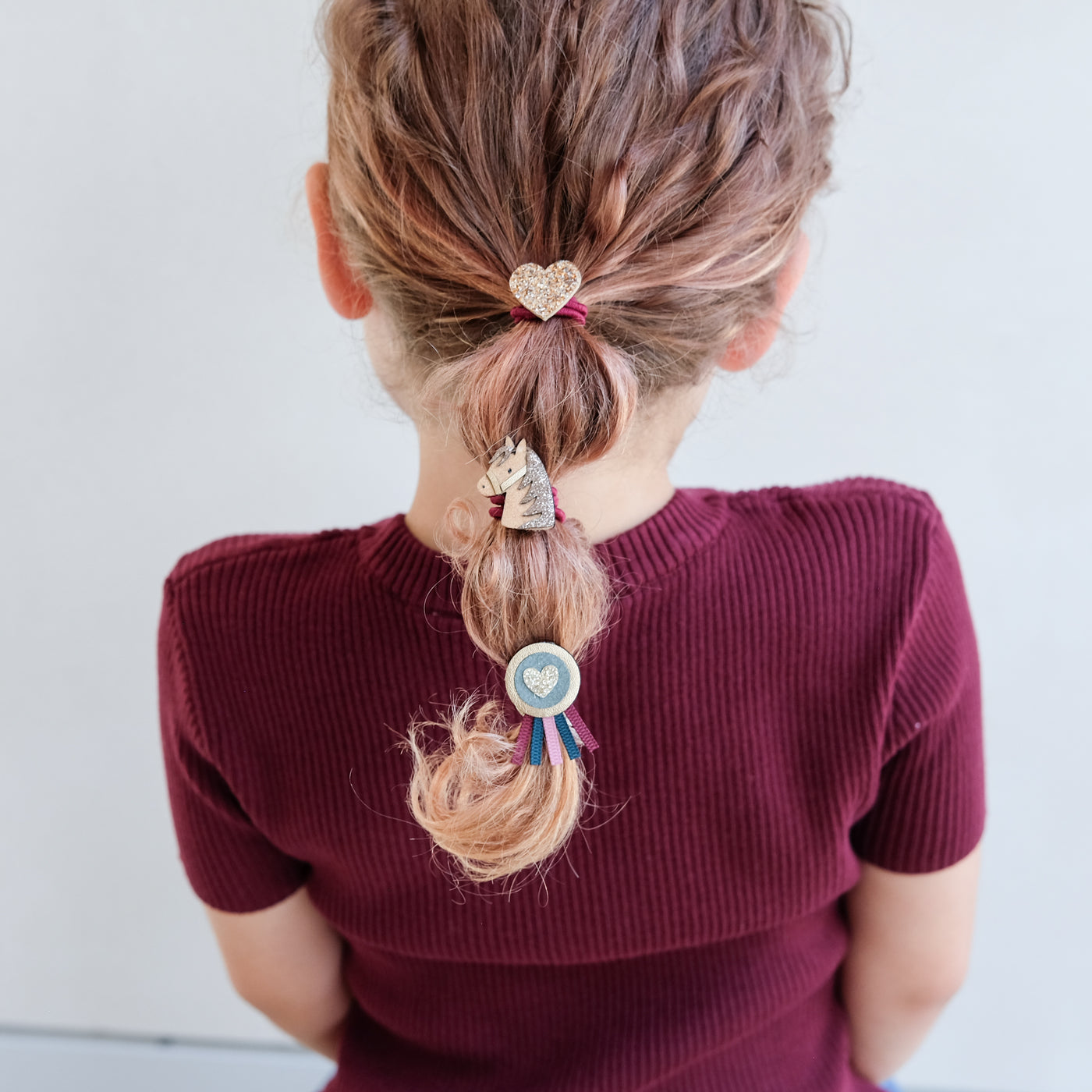 girl wearing pony pals ponies in hair against a white background