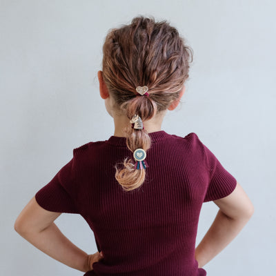 girl wearing pony pals ponies in hair against a white background