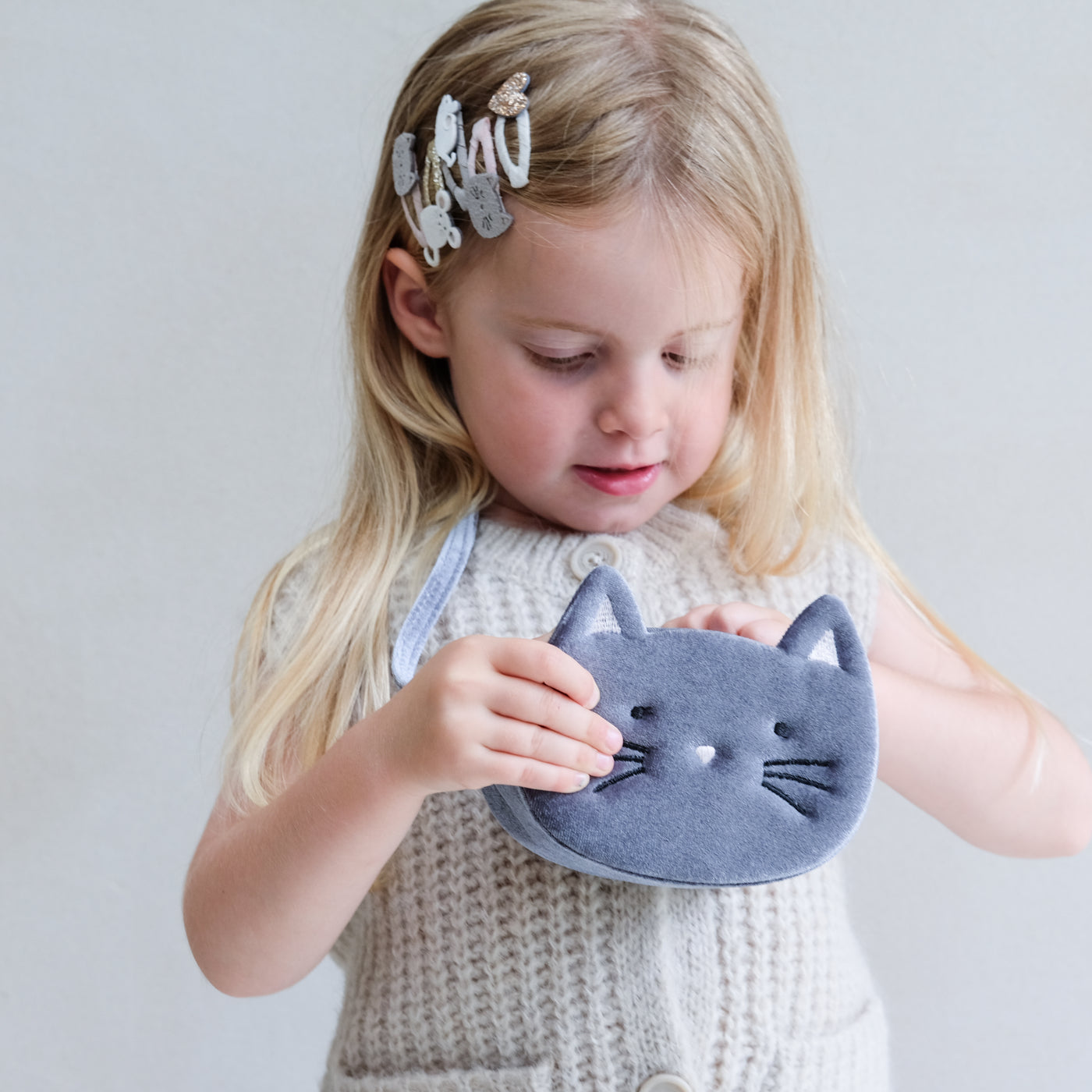 young girl wearing Kitty cat clic clac hair clips in her hair against a plain background