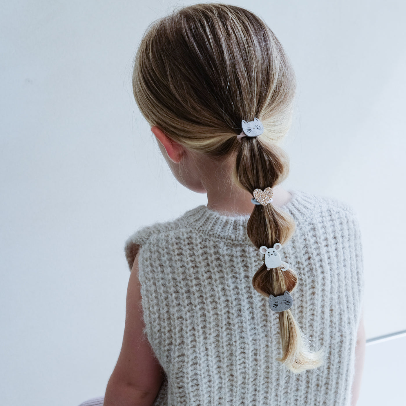 little blonde girl with 'bubble' ponytail decorated with mini cat and mouse themed cute bobbles