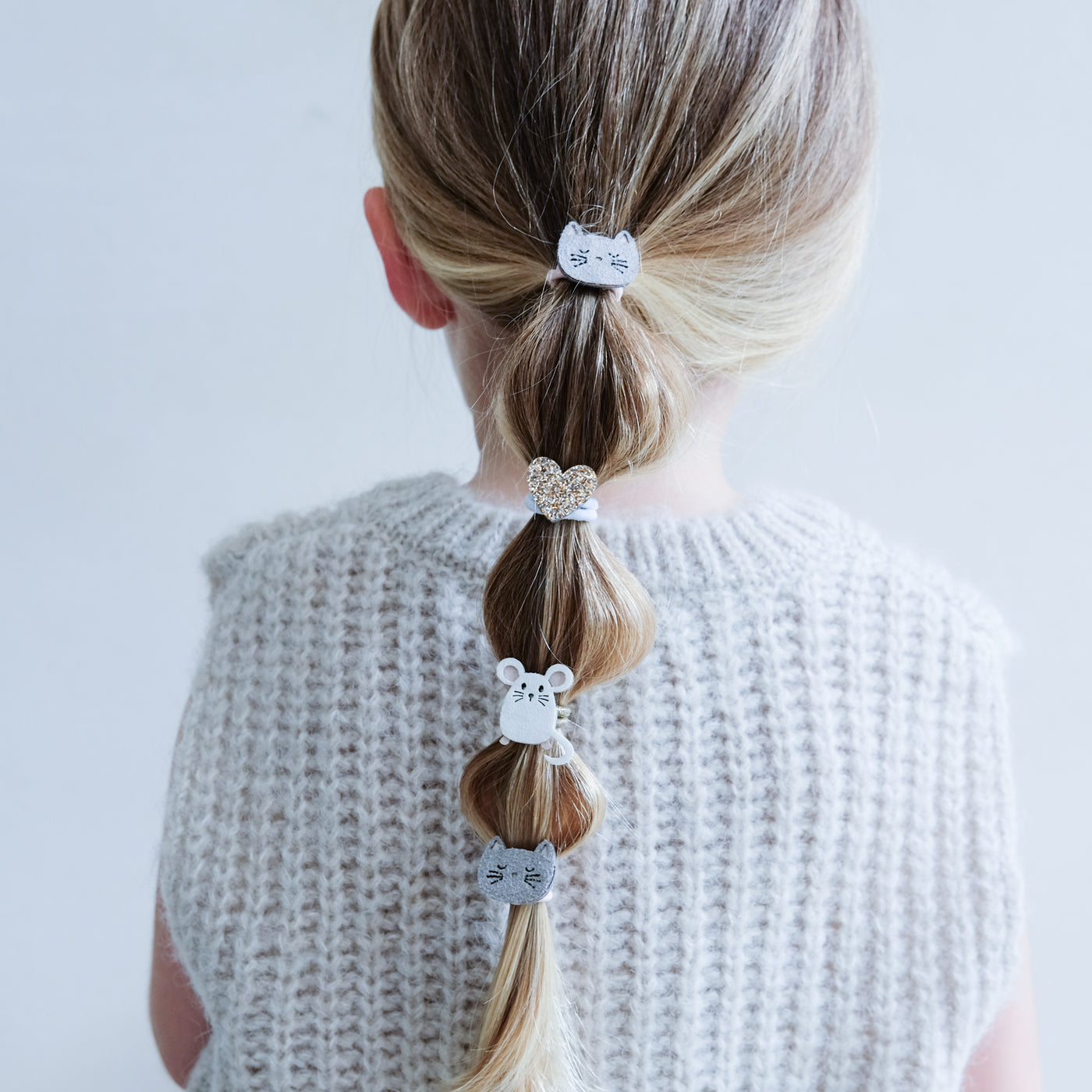 little blonde girl with 'bubble' ponytail decorated with mini cat and mouse themed cute bobbles