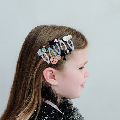 girl with monster mini hair clip clic clacs in her hair against a plain background