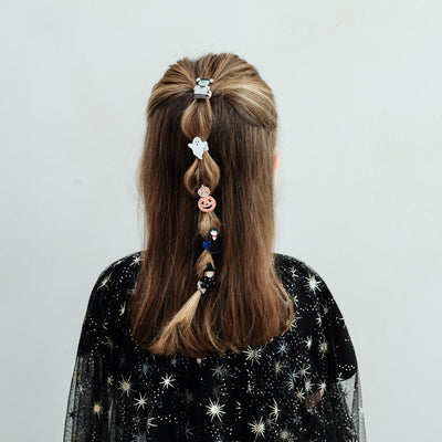 girl wearing monster mini ponies in her hair against a white background
