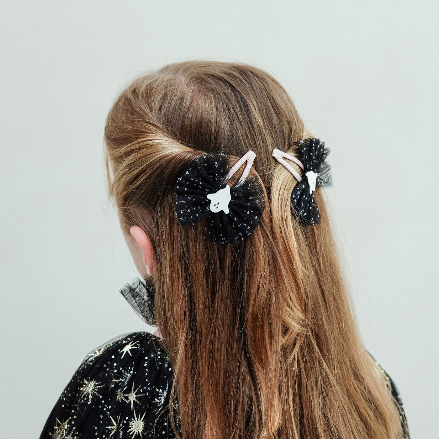 girl wearing Ghoulish ghost tulle clips in her hair against a white background