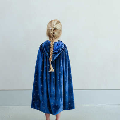 girl wearing an ice queen velvet cape against a white background