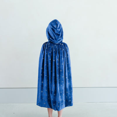 girl wearing an blue hooded ice queen velvet cape against a white background