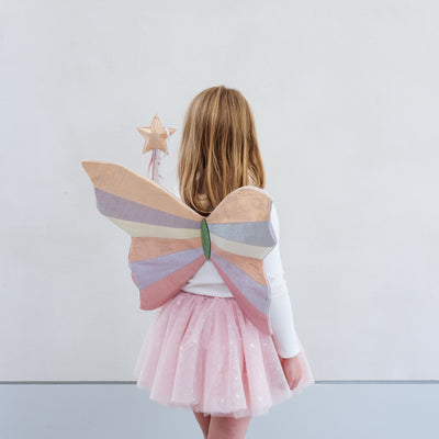 girl wearing sparkly intergalactic fairy wings and pink shimmer tutu against a white background