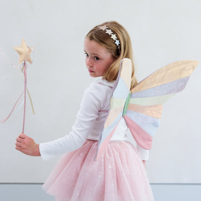girl wearing pink fairy costume against a white background